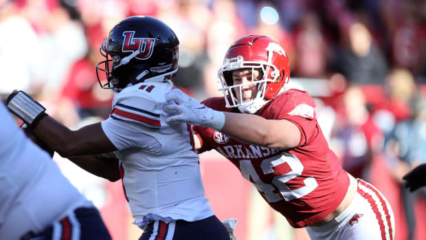 Arkansas Razorbacks linebacker Drew Sanders (42) tackles Liberty Flames quarterback Johnathan Bennett (11) in the second quarter at Donald W. Reynolds Razorback Stadium.